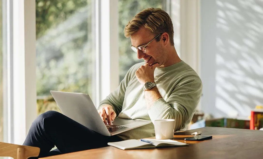 smiling man using laptop